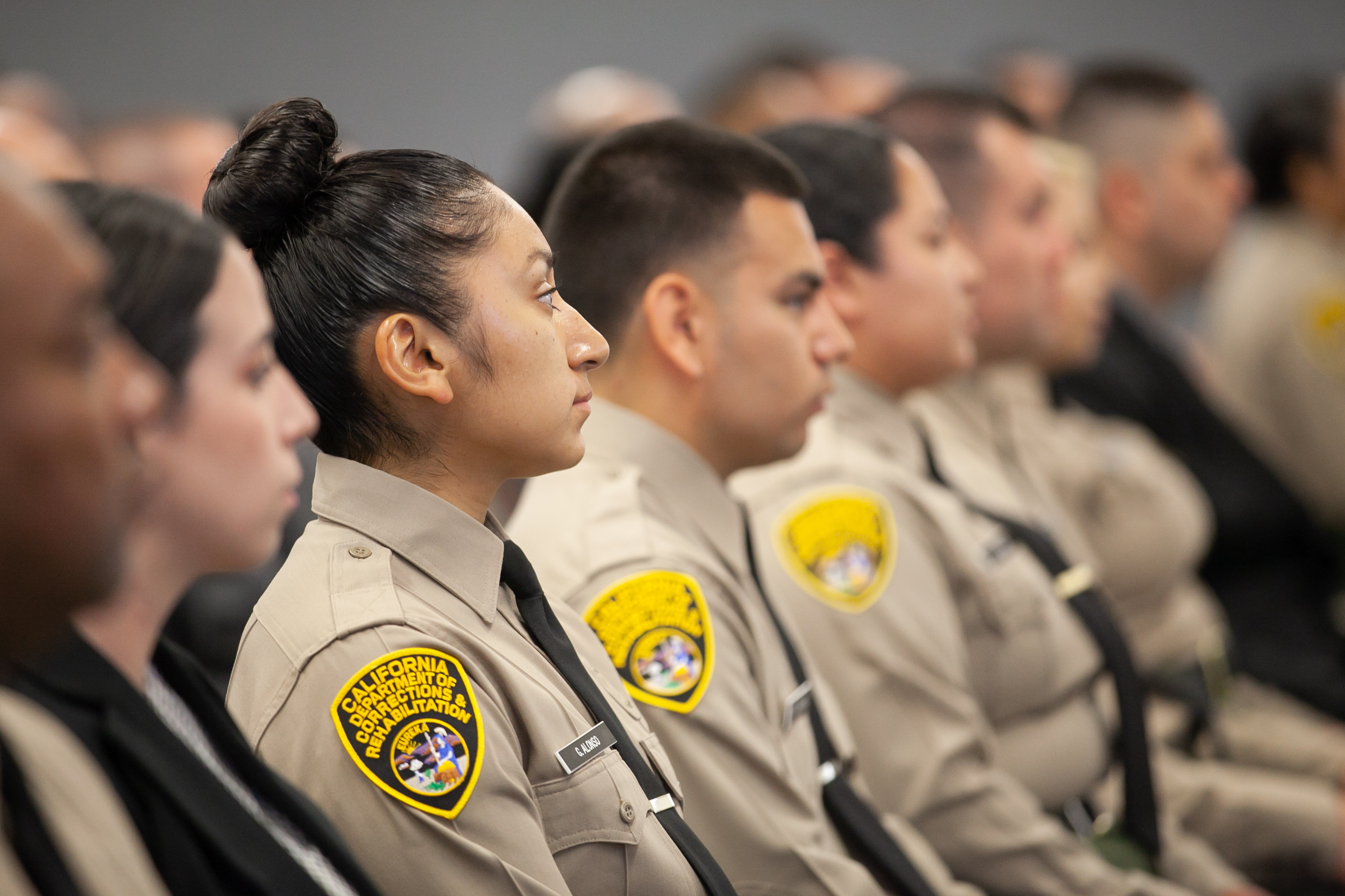 Newly sworn CDCR Officers seated at their graduation ceremony.