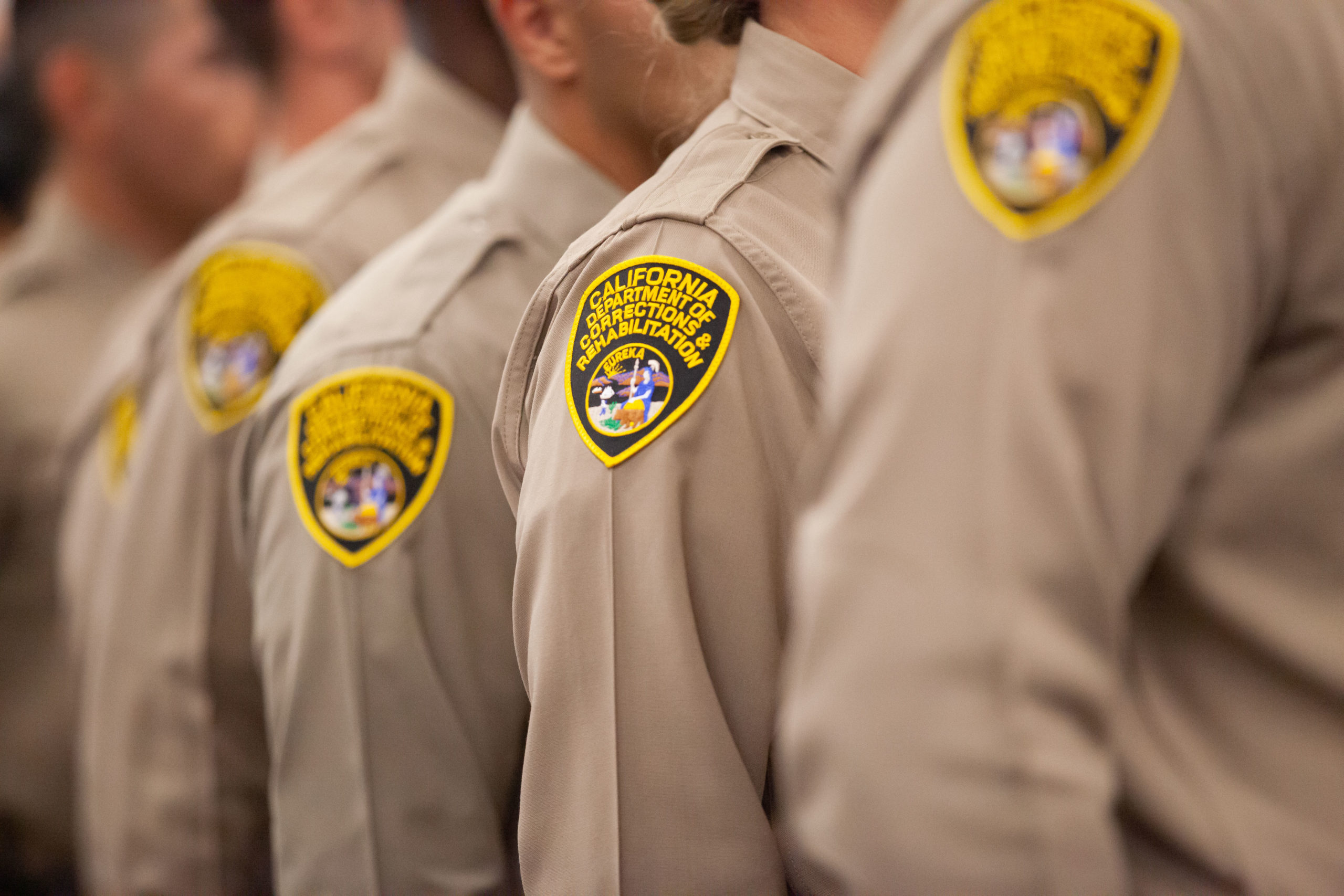 Newly sworn CDCR Officers standing in formation at a graduation ceremony.